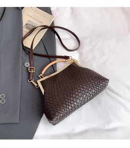 Détail du sac à main tressé marron foncé avec cadre métallique rétro et poignée en bois