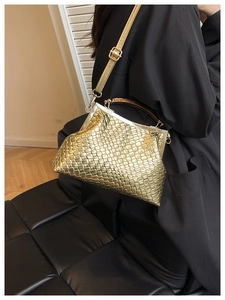 Détail du sac bandoulière doré tressé avec poignée en bois et fermoir en métal