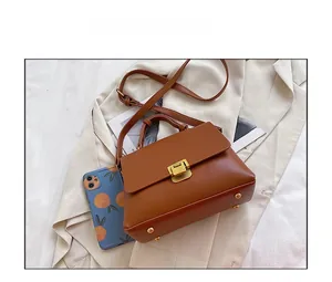 Détail du sac cabas marron texture lychee avec fermoir doré et téléphone pour la taille