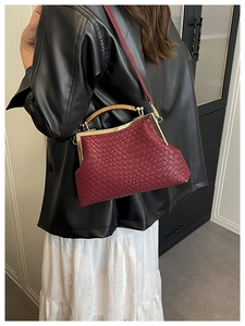 Mannequin portant un sac en cuir tressé bordeaux avec une poignée vintage dorée