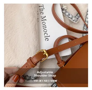 Détail de la bandoulière réglable en cuir marron avec boucle dorée et coutures précises