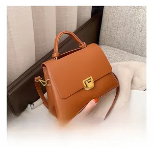 Vue détaillée du sac bandoulière marron caramel avec boucle dorée sur tissu doux