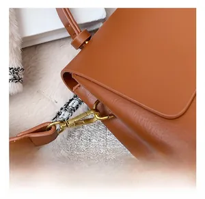 Vue détaillée du crochet en bronze vintage et de la texture du cuir brun sur le sac