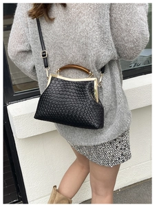Détails de la texture en cuir tressé noir avec fermoir vintage et poignée en bois