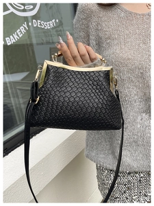 Détail du sac à main en cuir tressé noir avec fermoir doré vintage et poignée en bois