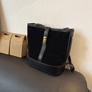 Retro black bucket shoulder bag with matte suede finish and gold twist-lock buckle
