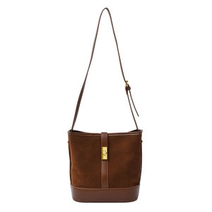 Retro brown suede and leather bucket bag with gold clasp shown from a front angle
