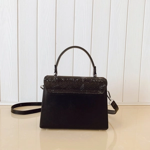 Detail of black faux snakeskin texture and silver hardware on a mini box handbag