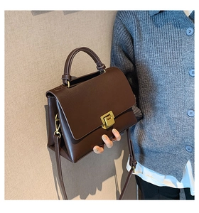 Détails d'un sac à bandoulière vintage marron foncé avec un fermoir doré mat élégant