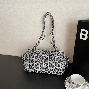Leopard print bowling shoulder bag in soft leather featuring adjustable straps and retro style