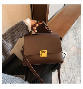 Detail of dark brown vintage small square bag with golden buckle and textured PU leather