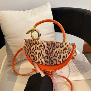 Fashionable leopard print handbag with orange base and metallic ring handle in lifestyle shot