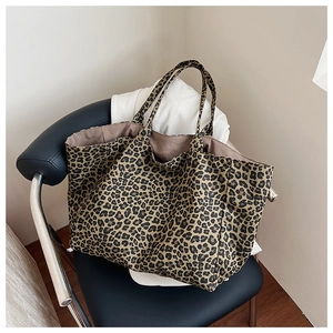 Detail of vintage leopard print tote bag with soft inner lining on a leather chair