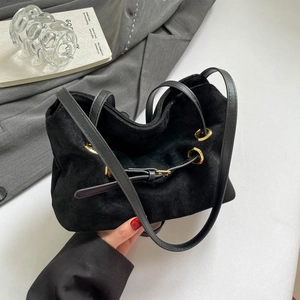 Large black faux suede shoulder bag with gold metal eyelets and a crossbody strap
