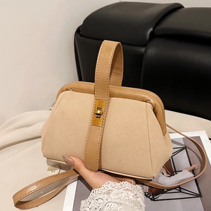Beige suede shell bag with gold lock and top handle for hand or crossbody wear