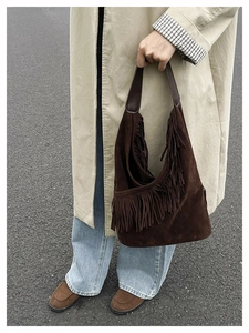Dettaglio della borsa hobo in pelle scamosciata marrone scuro con lunghe frange