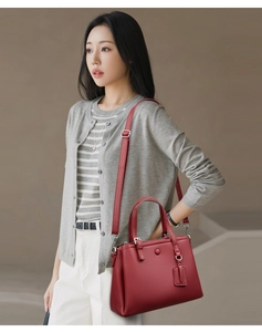 Détail du sac cabas en cuir rouge foncé avec texture fine et bandoulière réglable