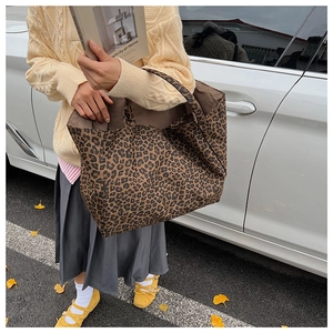 Street view of a large leopard print canvas tote bag featuring classic brown and black patterns