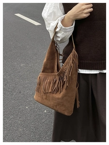 Dettaglio della borsa tote in pelle scamosciata marrone scuro con nappe a frangia a V