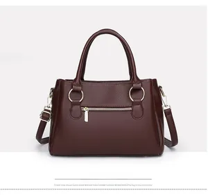 Dettaglio della borsa bordeaux in pelle martellata con anelli dorati e cerniera chic