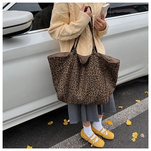 Detail of vintage leopard print canvas tote bag carried by a model in autumn street scene