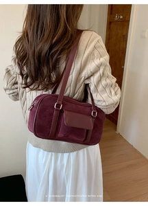 Detail of burgundy faux suede shoulder bag with retro minimalist design and flap pocket