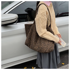 Close-up of leopard print canvas tote bag with wide strap on a model for daily use