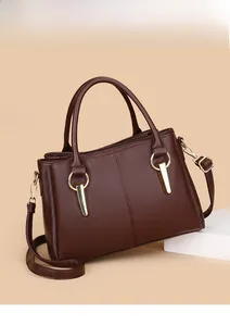 Dettaglio borsa tote in pelle marrone scuro con trama venata e dettagli dorati