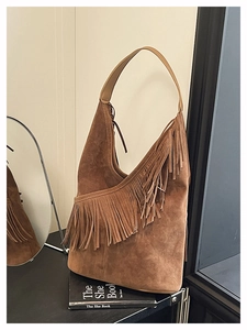 Dettaglio di una borsa hobo in camoscio marrone con frange lunghe e manici in pelle