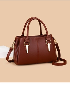 Dettaglio borsa tote in pelle marrone con anello dorato e tracolla regolabile