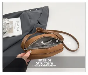 Close-up of brown suede crossbody bag interior with main pocket and zipper compartment