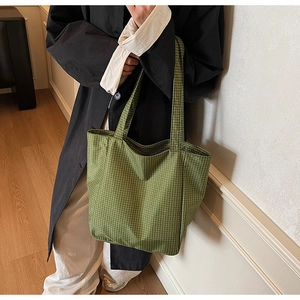 Close-up of green checkered canvas tote bag showing durable texture and wide strap