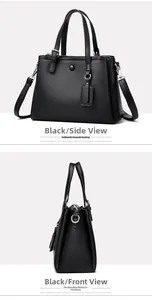 Détail du sac à main noir en cuir grainé avec double poignée et anneaux métalliques en D