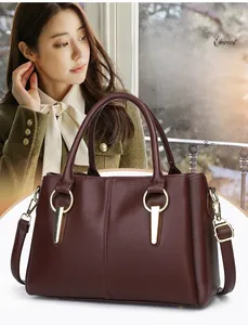 Dettaglio della borsa in pelle rosso scuro con eleganti anelli metallici dorati
