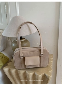 Detail of warm beige baguette bag in suede and smooth leather on artistic base