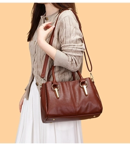 Dettaglio borsa tote in pelle martellata marrone con finiture metalliche dorate