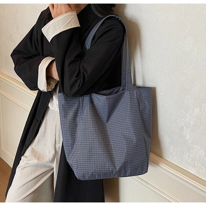 Detail of minimalist checkered canvas tote bag with a woven blue and white texture