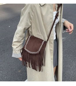 Scatto street style di una borsa a tracolla marrone scamosciata con frange