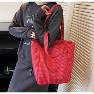 Detail of red checkered canvas tote bag showing large capacity and soft fabric texture