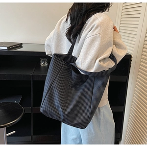 Detail view of navy checkerboard canvas tote bag with wide strap for daily commute