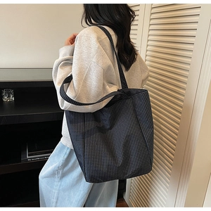 Deep blue and black checkered canvas tote bag shown in a daily lifestyle fashion setting
