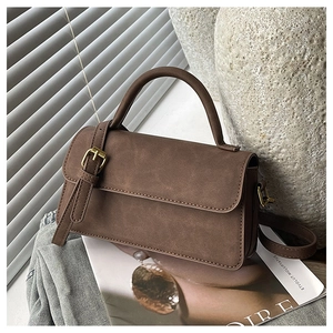 Détail du sac bandoulière vintage marron avec finition mate et boucle en métal élégante