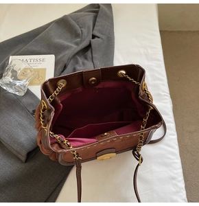 Detailed interior of vintage brown shoulder bag with magnetic clasp and chain strap