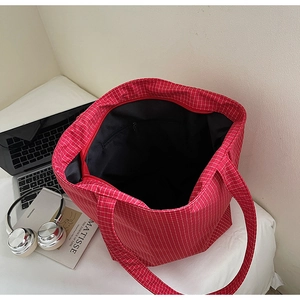 Detail of red and white checkered canvas tote bag with black lining and inner zipper pocket