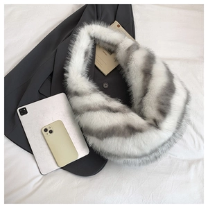 Close-up of fluffy white and grey faux fur collar paired with a grey blazer and accessories