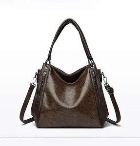 Detail of vintage brown tote bag showing textured faux leather and silver zipper accents