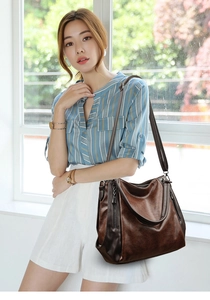 Detail view of dark brown retro tote bag featuring oily wax texture and metal zipper