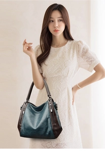 Detail of teal and brown leather tote bag with silver hardware and vintage texture
