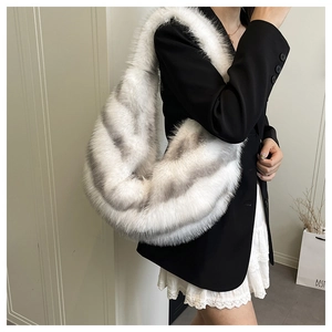 Close-up of fluffy faux fur hobo bag with grey gradient texture worn on shoulder