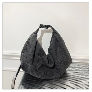 Detailed macro view of the grey denim tote bag showing fabric texture and buckle